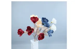 Detailed view of multi-color artificial magnolia flowers in a minimalist white ceramic vase