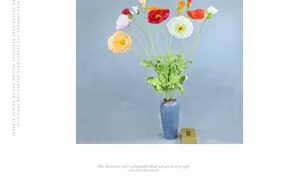 Detail of colorful artificial poppies in a blue ceramic vase for home decoration