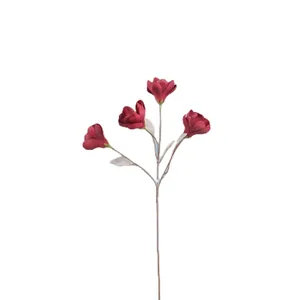 Artificial magnolia branch with four dark red faux silk flowers on white background