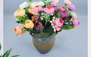Gros plan de roses artificielles et renoncules dans un vase en céramique pour la décoration