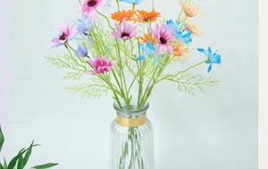 Bunter Kunstblumenstrauß mit Gänseblümchen in Rosa, Blau und Orange in einer Glasvase