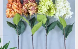 Dettaglio di petali di ortensia artificiale e foglie in arancione, rosa e bianco
