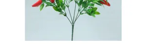 Dettaglio di un ramo di peperoncino rosso artificiale con foglie verdi per decorazione