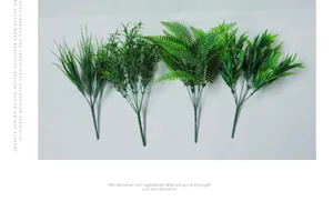 Dettaglio di quattro steli di felce e erba artificiale per decorazione d'interni