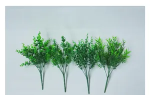 Dettaglio di quattro rami di piante verdi artificiali per decorazione della tavola