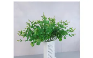 Detail of 16-fork artificial eucalyptus plant in a white ceramic vase on gray table
