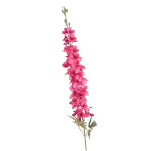 Delphinium artificiel avec fleurs en soie magenta et feuilles vertes sur un fond blanc pur