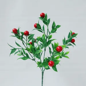 Ramo di bacche rosse artificiali con foglie verdi in vaso di vetro per decoro tavola
