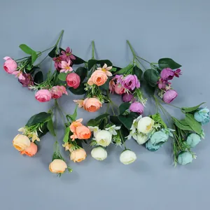 Vue à plat de bouquets de roses et camélias artificiels colorés sur fond bleu ciel