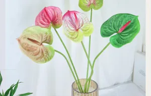 Dettaglio di fiori di anthurium artificiali rosa e verdi in un vaso di vetro decorativo
