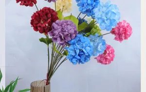 Close-up of colorful artificial hydrangea bouquet in a textured glass vase