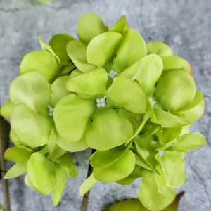 Green artificial hydrangea silk flower bouquet on a grey stone texture background