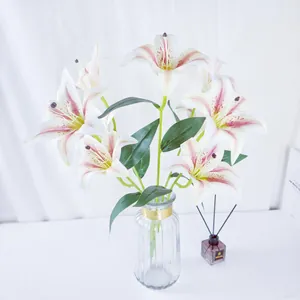 Bouquet de lys artificiels à 9 têtes dans un vase en verre côtelé avec bord doré