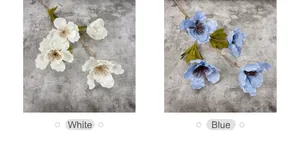 Detalle de hibiscos artificiales blancos y azules con pétalos de seda y hojas realistas