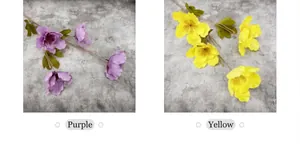 Detalle de flores de hibisco artificiales moradas y amarillas con pétalos de seda