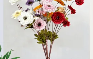 Primer plano de peonías artificiales multicolores con pétalos en capas y tallos naturales