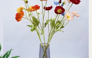 Bouquet di papaveri finti colorati con steli floccati in un vaso di vetro viola