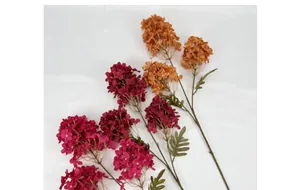 Detail of rose red and caramel orange artificial hydrangeas with realistic green leaves