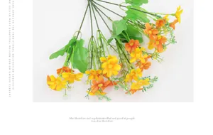 Detailed overhead view of artificial yellow and orange silk daisies with green stems