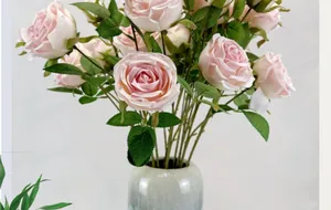 Détail de roses Austin artificielles roses avec feuilles réalistes dans un vase céramique