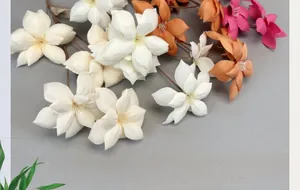 Detail view of colorful artificial 5-head silk flowers in white orange and magenta colors