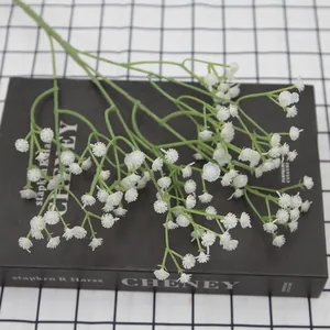Artificial white gypsophila baby's breath flowers on a book for home decoration