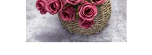 Détail de roses artificielles roses vintage dans un panier en paille tressée rustique