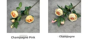 Detail of silk roses in champagne pink and champagne with blooming heads and green leaves