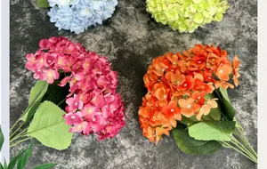 Top view of vibrant hydrangea silk flowers in blue, green, and red on marble surface