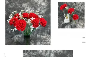 Macro detail of red velvet carnation silk flowers and white baby's breath in glass vase