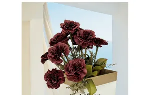Deep red artificial carnation bouquet in a stylish white gift bag for home decor
