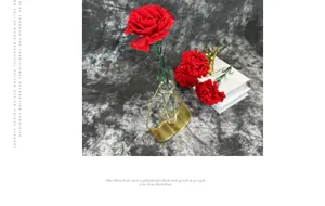 Detail of a gold heart-shaped metal vase with a red carnation for Mother's Day decor