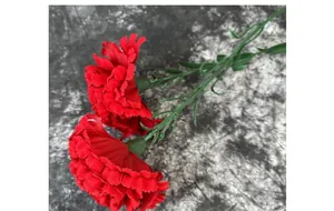 Close-up of velvet red artificial carnations with layered petals and green stems