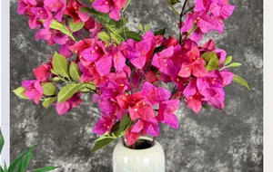 Detail of vivid magenta bougainvillea silk flowers in a white ceramic vase decoration