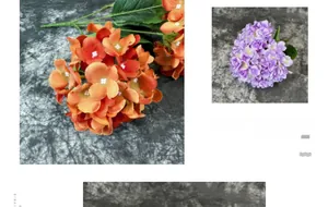Detail of silk hydrangea flowers with orange and purple petals on a textured grey background