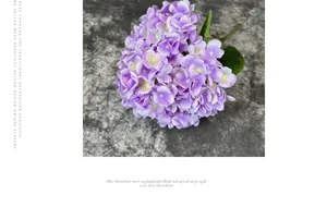 Close-up of artificial purple hydrangea with realistic silk petals and green leaves