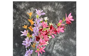 Detail shot of multicolor artificial lily silk flowers with green leaves and long yellow stamens