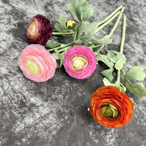 Single stem artificial camellia flowers in four colors on dark textured fabric background