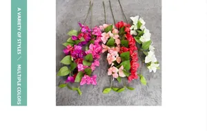 Flat lay of artificial bougainvillea branches in five colors on a textured grey background