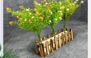 Artificial plants in a rustic wooden fence planter with small colorful faux flowers