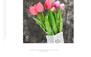 Detail of colorful artificial PU tulips in a white ceramic vase with decorative text