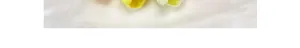 Macro detail of three bright yellow artificial PU tulips on white textured silk fabric