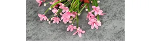 Detailaufnahme von rosa Seidenblumen mit grünen Blättern und weißen Knospen