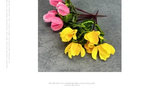 Detailed close-up of realistic pink and yellow artificial cyclamen flowers with textured leaves