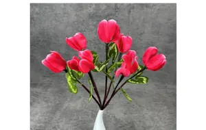 Detailed view of artificial cyclamen flowers with deep rose petals and heart-shaped leaves