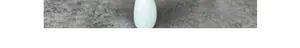 Minimalist white egg-shaped ceramic flower pot on textured grey stone surface detail
