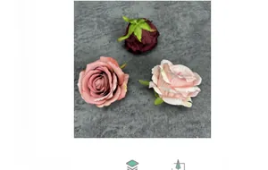 Detail of matte fabric artificial rose heads in deep red and dusty pink with realistic petals