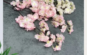 Macro view of detailed pink and cream artificial cherry blossom petals on brown branches
