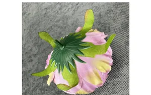 Detailweergave van kunstmatige pioenroos in roze en geel met groene plastic kelk
