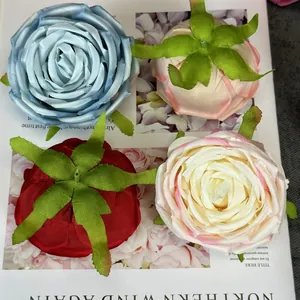 Artificial rose heads in red, pink, blue, and cream colors on a floral magazine